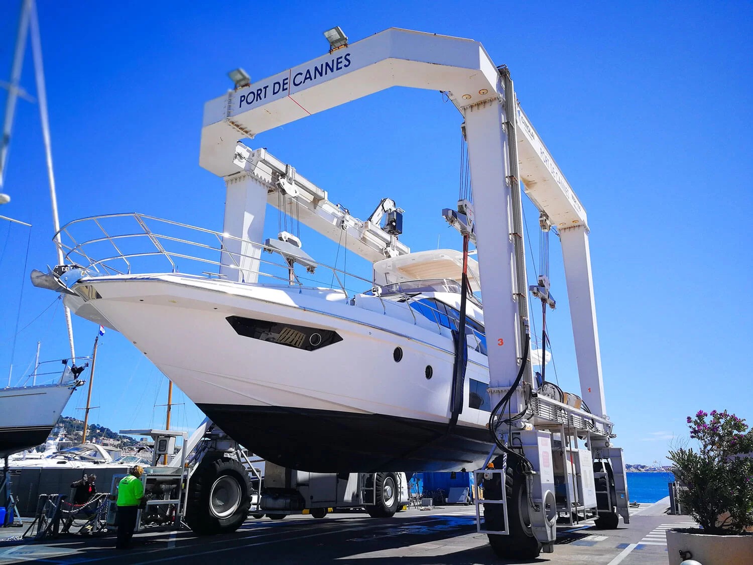 Yacht being lifted by travel lift crane at Port de Cannes