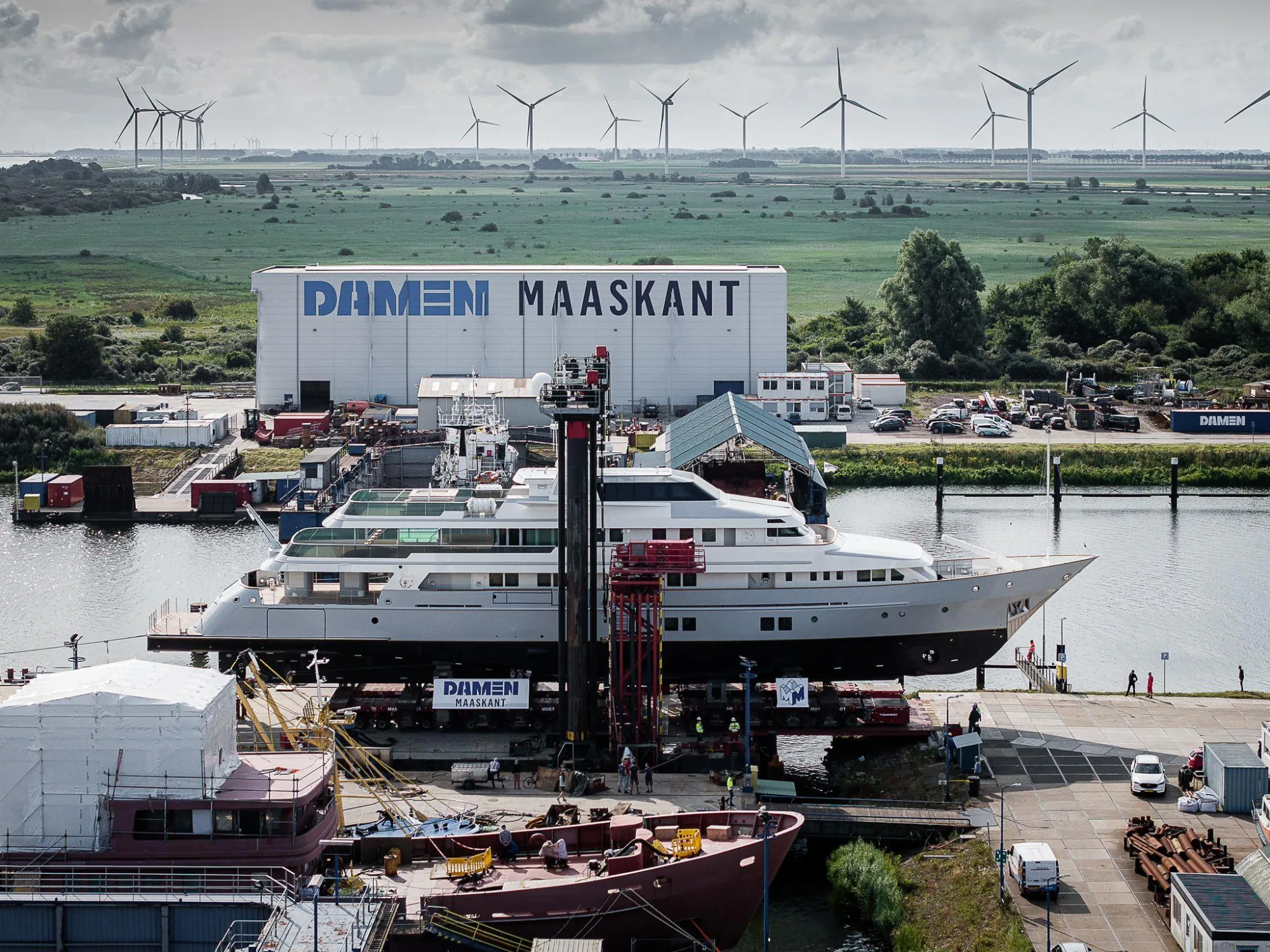 A yacht hauled out in front of the Damen Maaskant refit hall at Stellendam