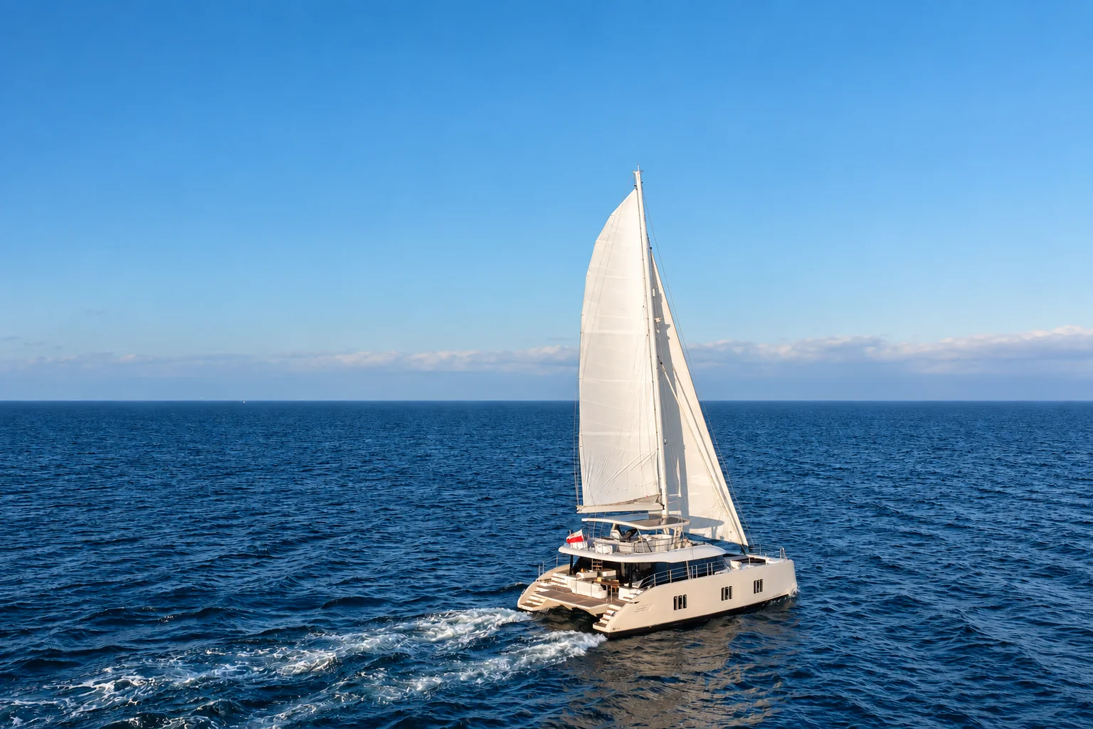 A sailing catamaran crossing open water.