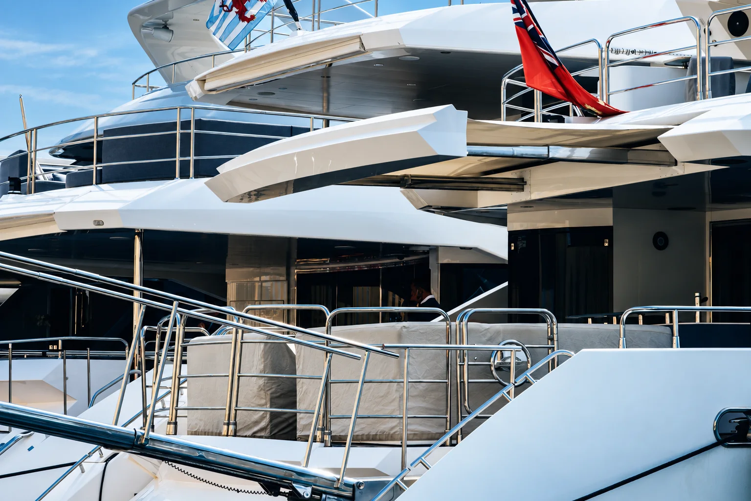 The stern of a luxury yacht flying maritime flags.