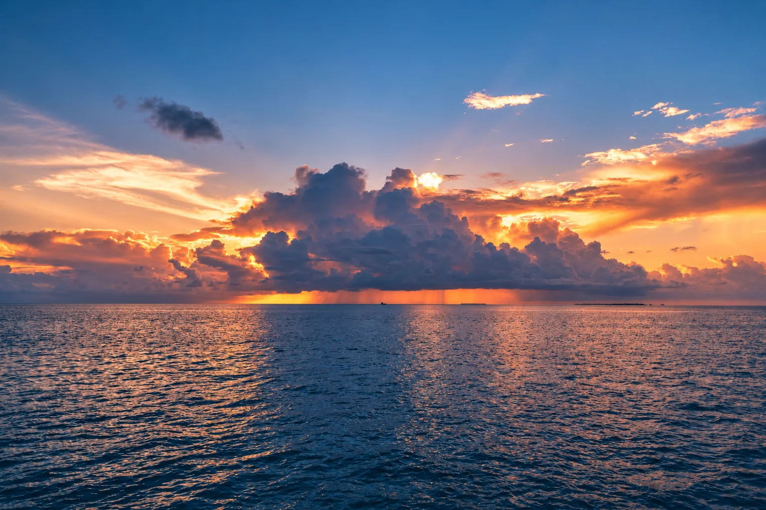 A broad ocean horizon beneath gathering storm clouds.