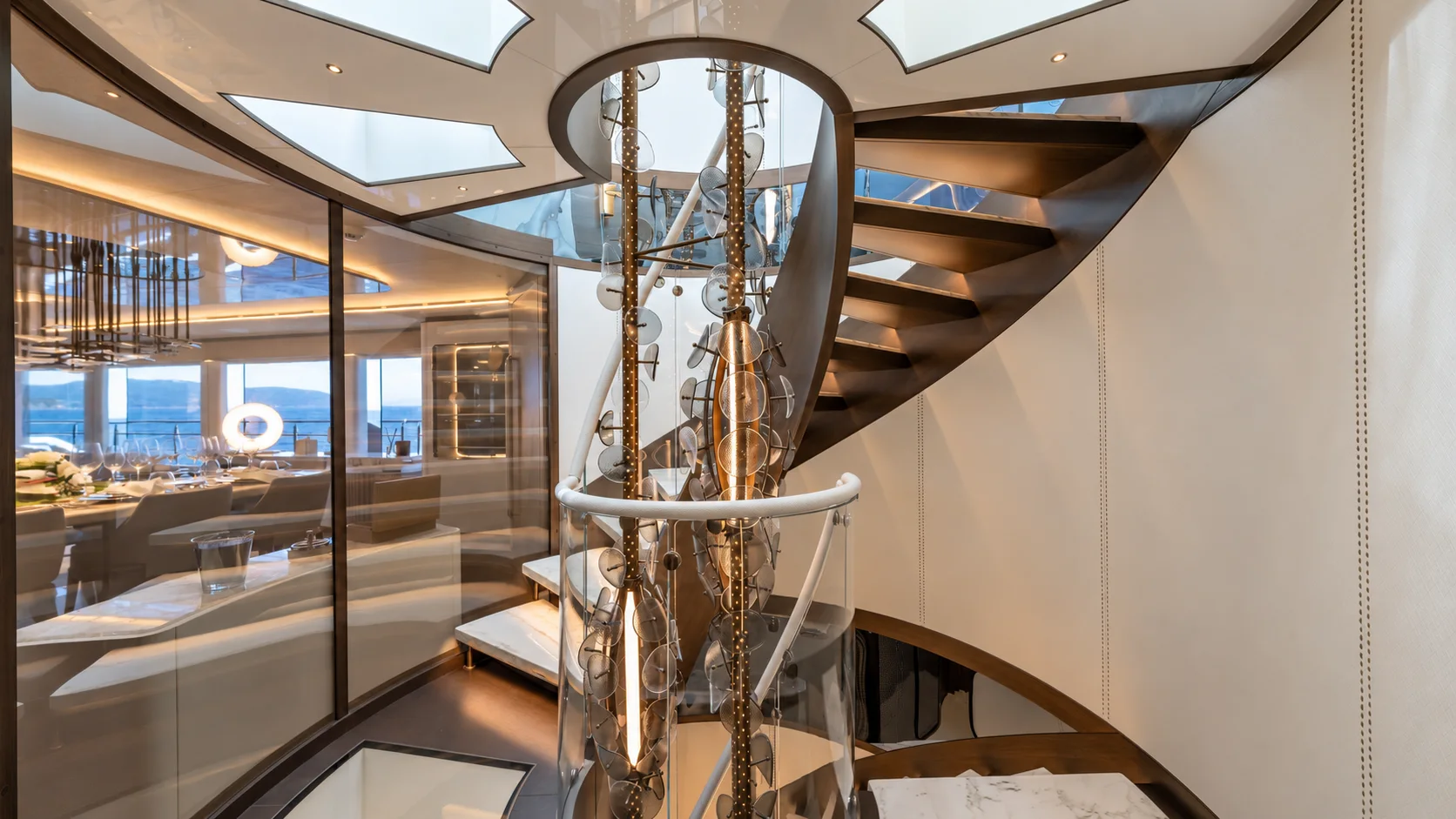 A luxury yacht atrium centred on a spiral staircase.