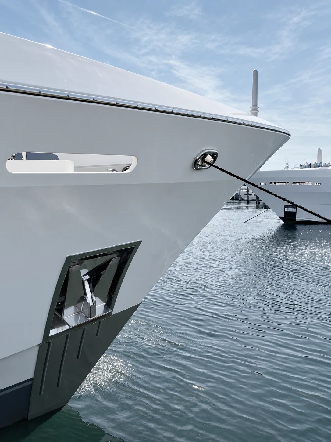 The glossy bow of a yacht in a marina.