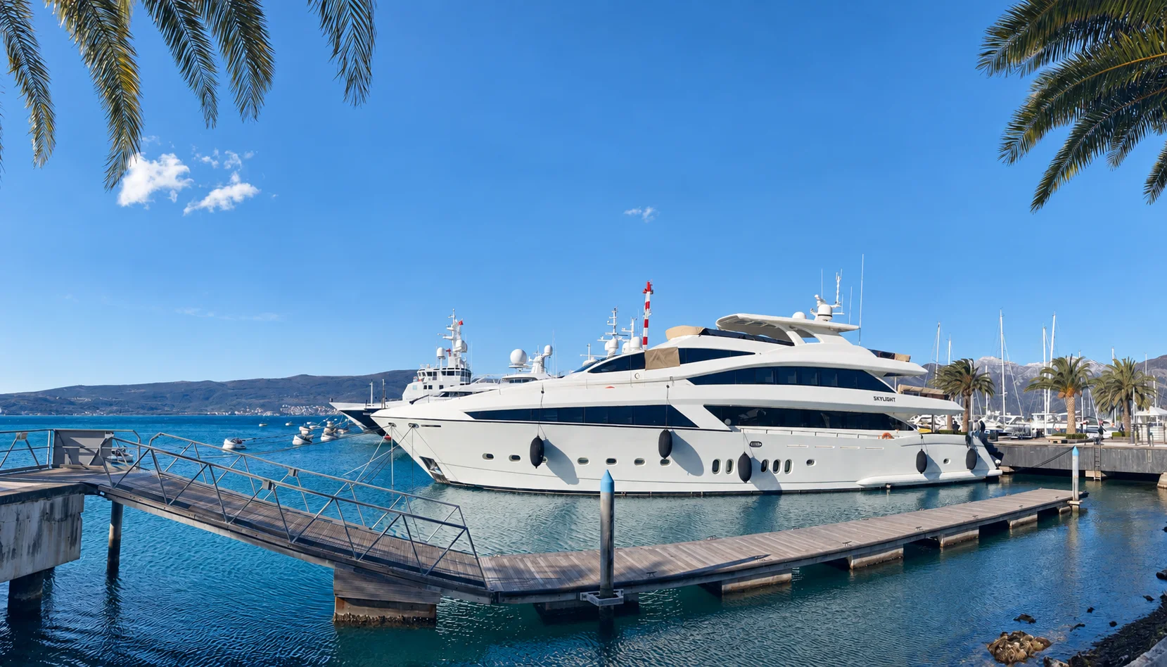 A luxury yacht berthed in a sunlit marina.