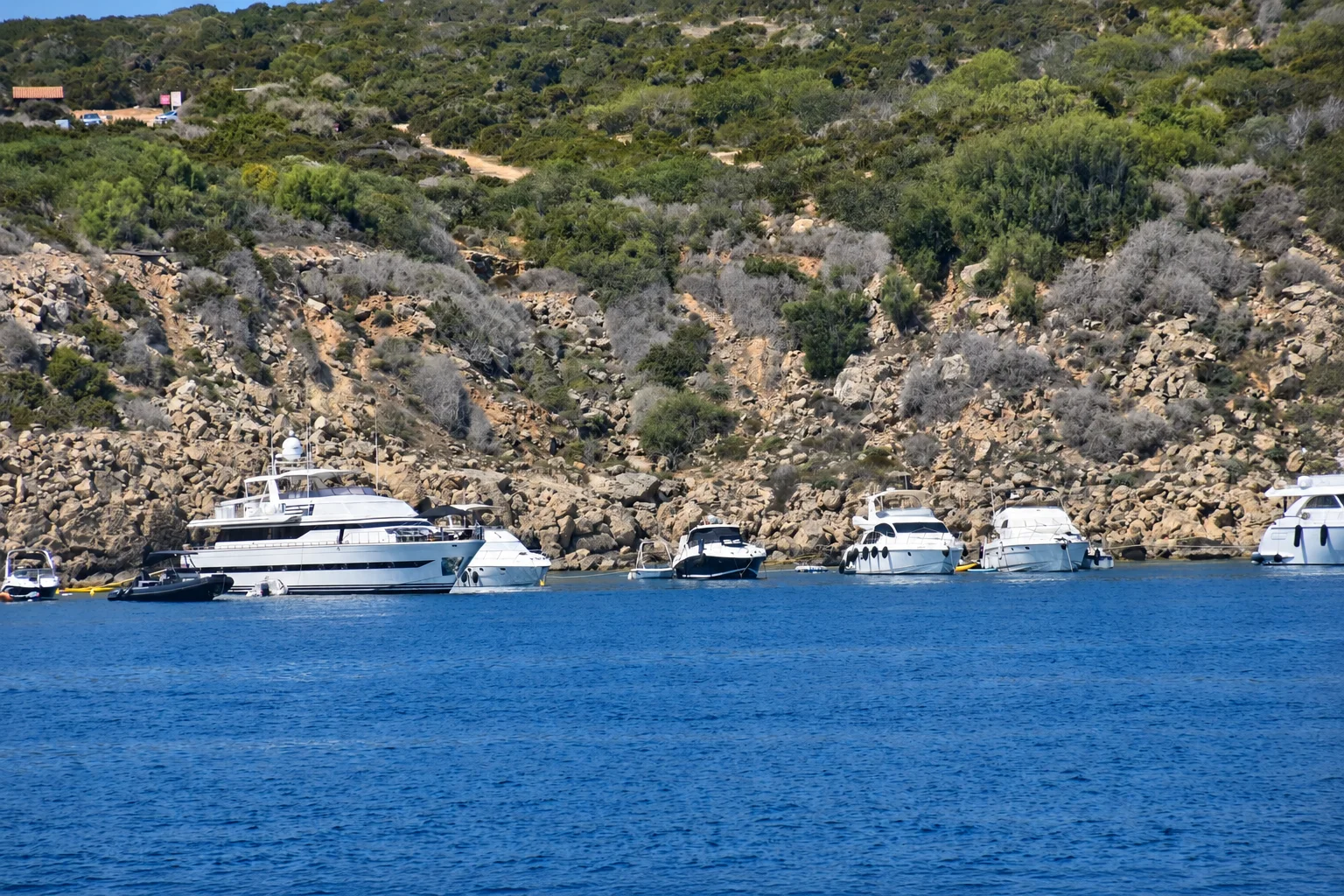 Yachts gathered in a Mediterranean cove.