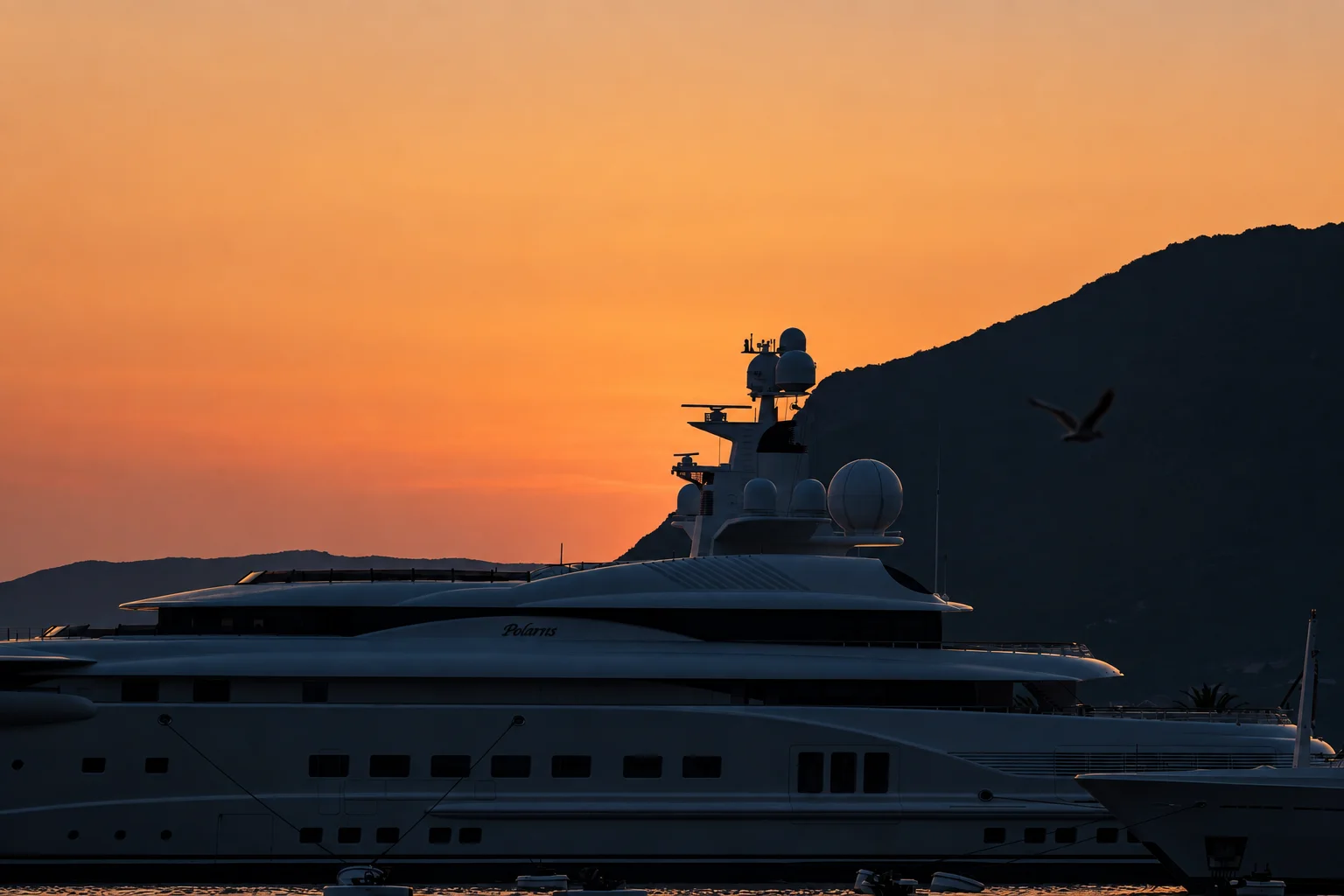 A yacht silhouetted against the sunset.