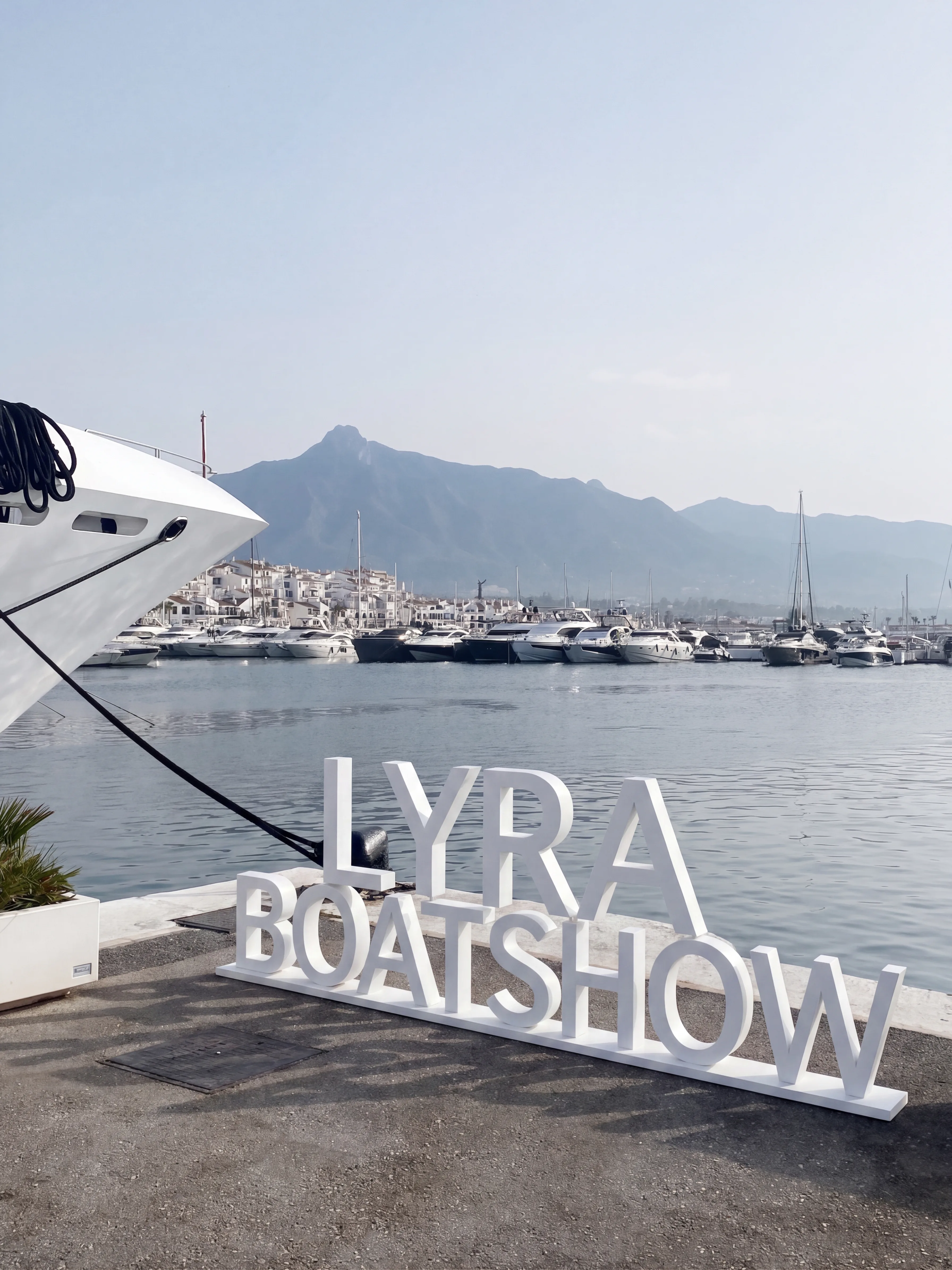 Motor yacht under way, its open deck terrace and salon glazing visible from the bow quarter