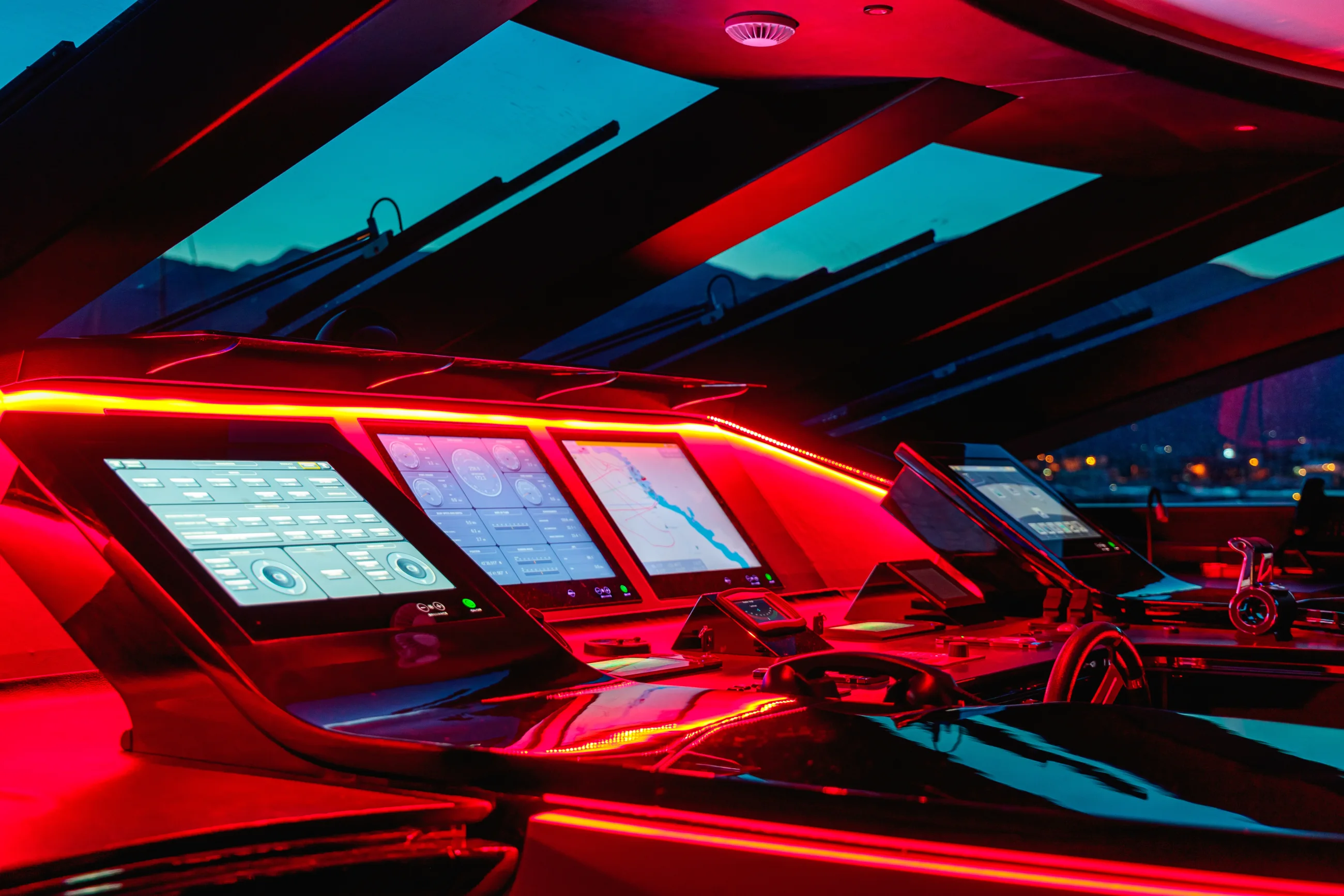 Rot beleuchtete Navigationsdisplays auf der Brücke einer modernen Yacht