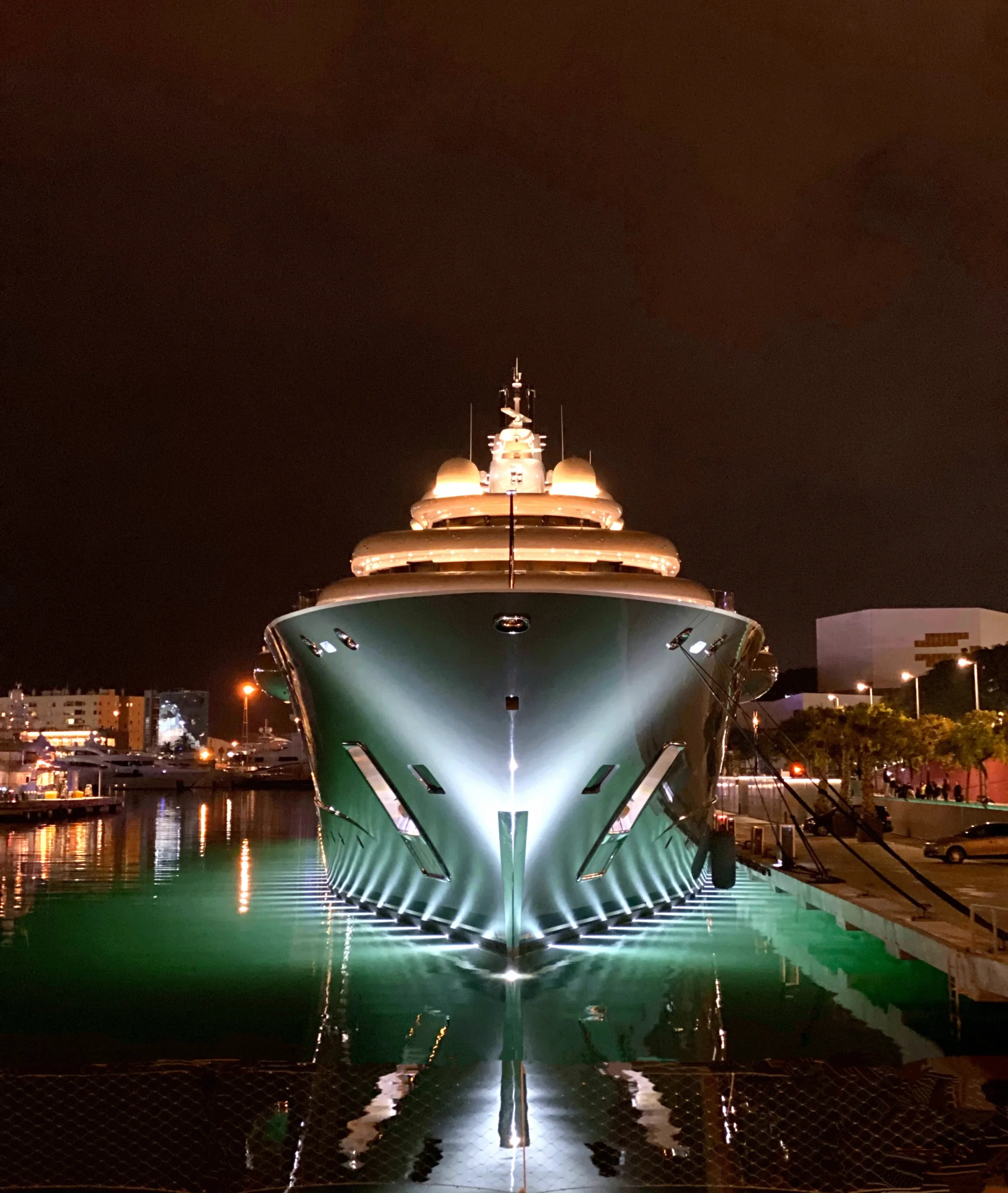 The illuminated bow of a large yacht moored at night